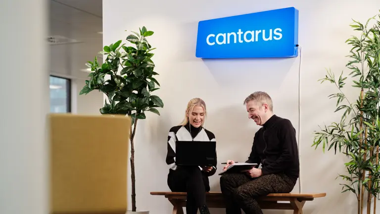 Two Cantarus developers chatting under neon sign