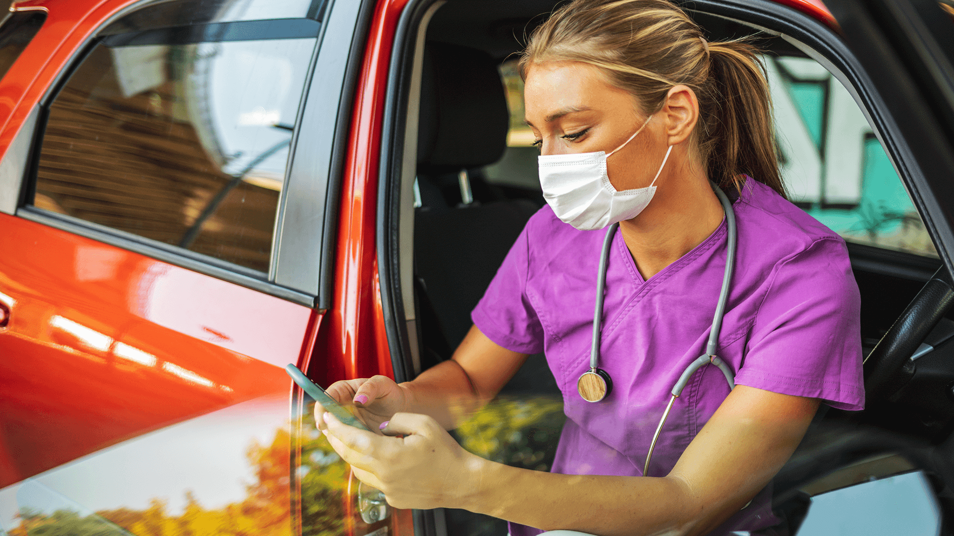 Nurse using phone to access vital data while on home visits