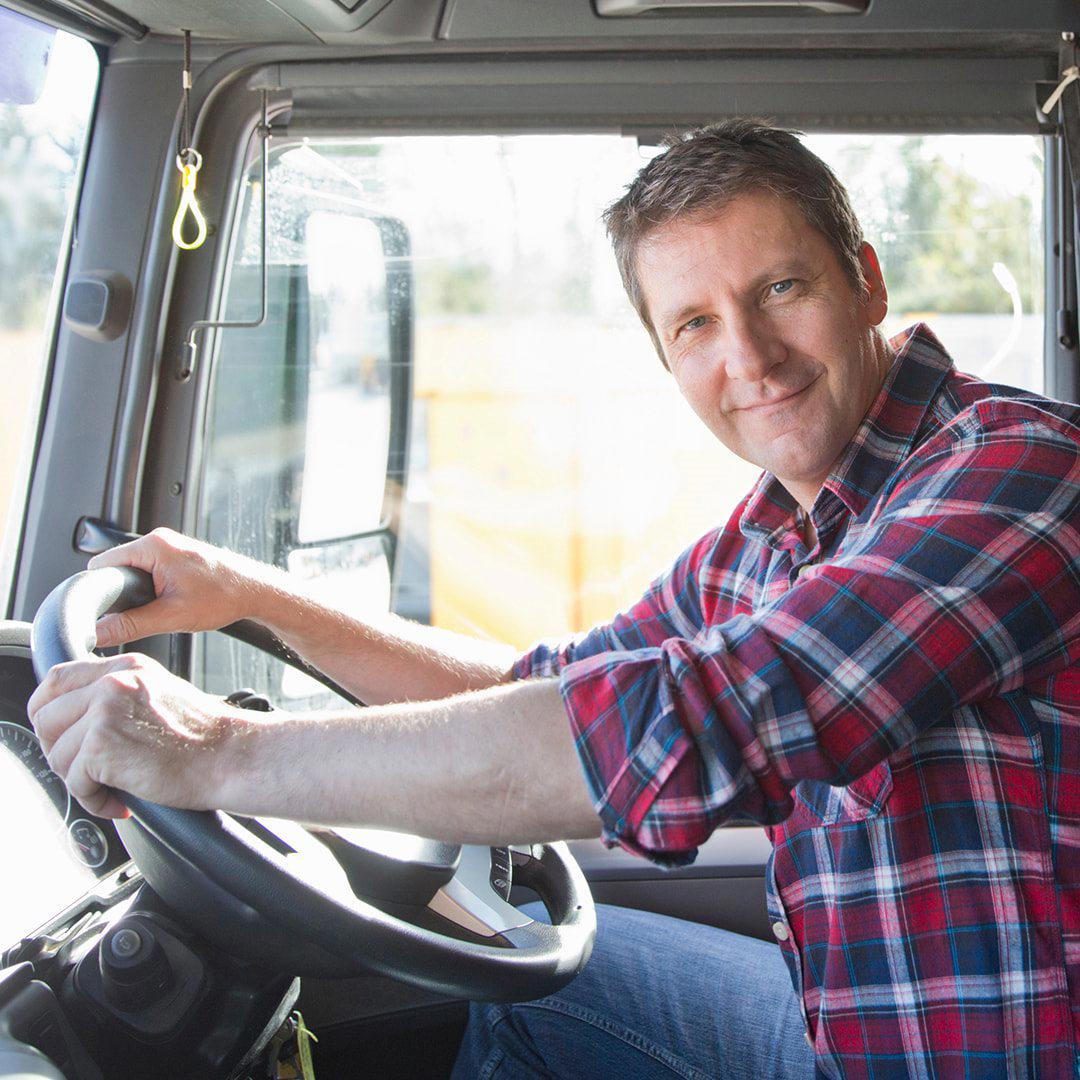 Male truck driver looking out of open cab door