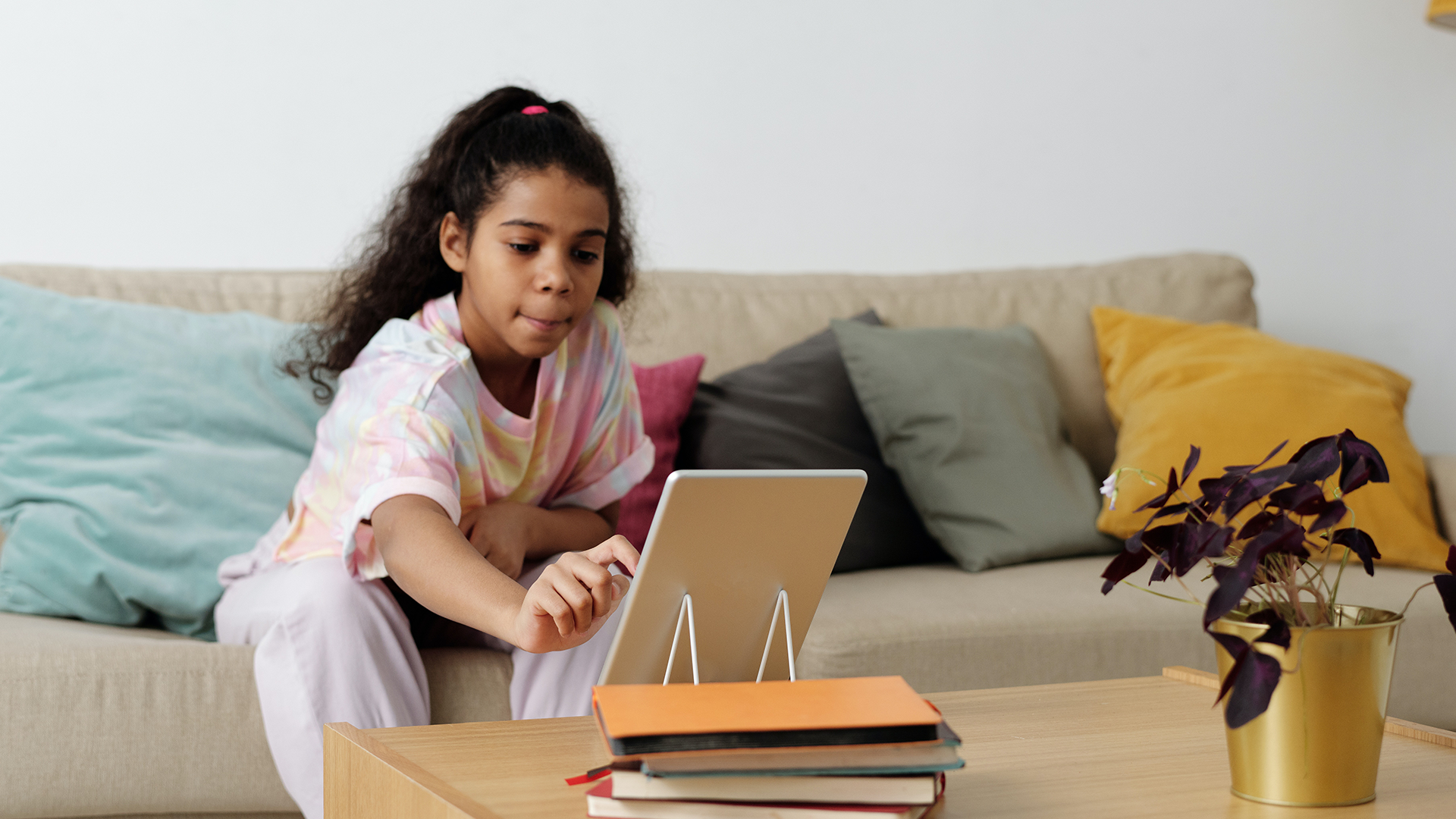 Young girl reading story on tablet device