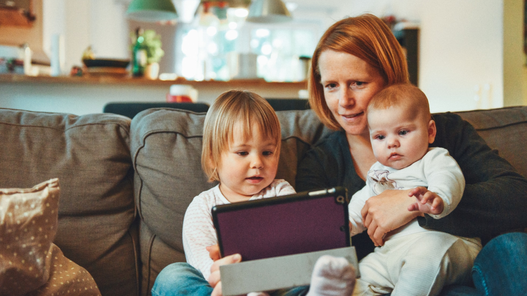 A woman with two young children browsing on a tablet device